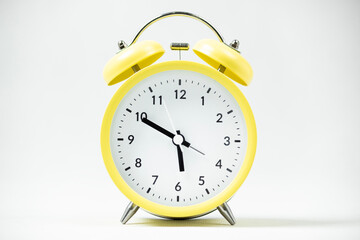 a classic analog yellow alarm clock with white background