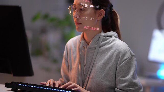 A software developer interacts with an augmented reality (AR) coding interface. Holographic data and script are projected onto her glasses as she programs a new system.