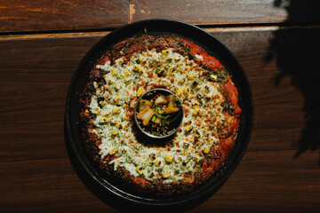 Sizzling Korean BBQ pork belly (samgyeopsal) on tabletop charcoal grill with rising smoke and...