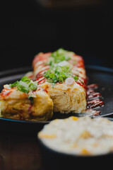 Sizzling Korean BBQ pork belly (samgyeopsal) on tabletop charcoal grill with rising smoke and traditional banchan side dishes, close-up shot in cozy restaurant setting with copy space.