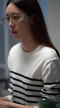 A female software developer smiles after successfully debugging a complex script. She works in a high-tech environment, coding on a mechanical keyboard with RGB backlighting.