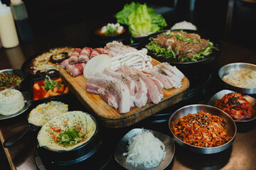 Grilled Korean beef short ribs (galbi) with caramelized edges on hot grill, served with lettuce wraps and kimchi, authentic Korean barbecue dining experience, overhead view.