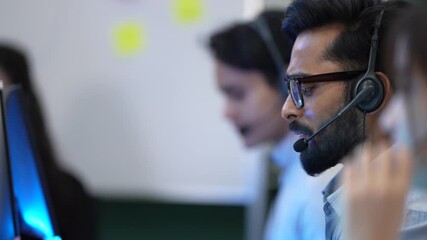 A diverse team of operators with headsets talks to customers in a busy call center. The professional staff is focused on helping people and providing good, efficient service. - Powered by Adobe