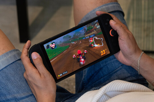 a man playing mario kart video game into a nintendo switch system