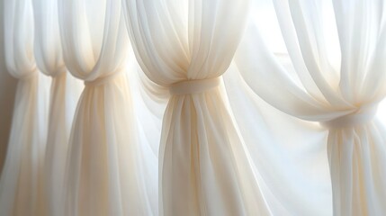 Soft white translucent curtains tied in gentle knots allowing diffused natural light to softly illuminate the room with an airy and calm ambiance