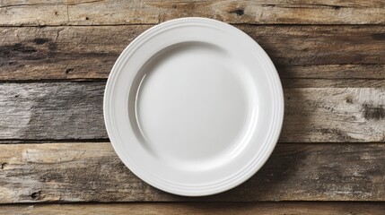 White ceramic plate with smooth rim on aged wooden planks. Top view