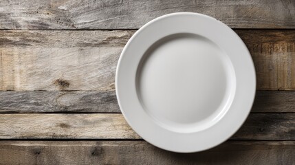 White ceramic plate with smooth rim on aged wooden planks. Top view