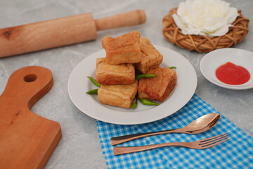 Golden Fried Tofu Cubes on a Plate with Chili and Sauce