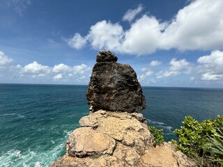 Sea Rock Pinnacle Amidst Turquoise Waters: A majestic rock formation, dramatically perched at the edge of a coastline, dominates the scene.