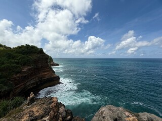 Seascape's Embrace: Panoramic view of the rugged coastal cliffs and tranquil ocean on a sunny day, where nature's raw beauty is masterfully captured. 