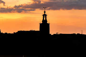 Silhouette view of Stockholm municipality city hall inspired by medieval architecture made of brick against the sunset sky