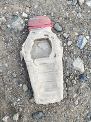 plastic bottle with water and garbage on the ground