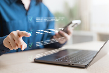 Fototapeta premium Close-up of woman using digital checklist interface on laptop and smartphone, concept of task management, productivity, project planning, online survey, and workflow automation.
