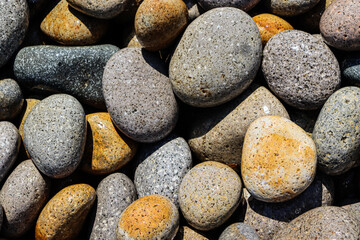 Large round sea stones. Rocky shore by the sea. Outdoor recreation.