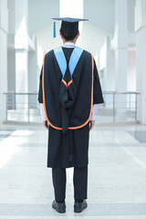Back view of graduates celebrating their college graduation with pride and joy on graduation day. Congratulations.