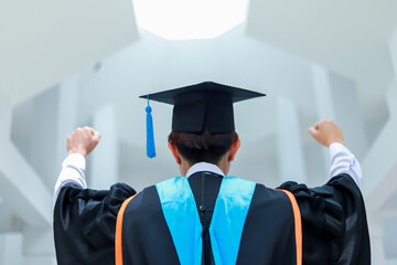 Back view of graduates celebrating their college graduation with pride and joy on graduation day. Congratulations.