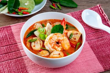 Prawn Tom Yum in a white bowl on a wooden table