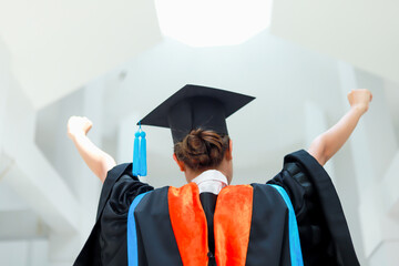Back view of graduates celebrating their college graduation with pride and joy on graduation day. Congratulations.
