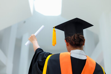 Back view of graduates celebrating their college graduation with pride and joy on graduation day. Congratulations.