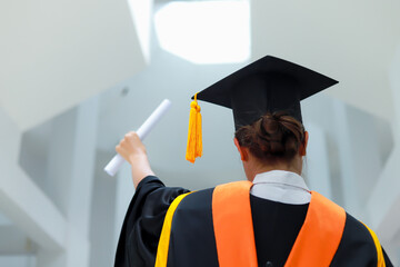 Back view of graduates celebrating their college graduation with pride and joy on graduation day. Congratulations.