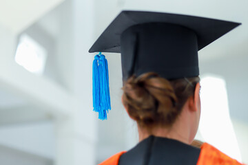 Back view of graduates celebrating their college graduation with pride and joy on graduation day. Congratulations.