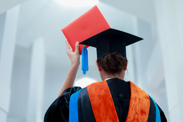 Back view of graduates celebrating their college graduation with pride and joy on graduation day. Congratulations.