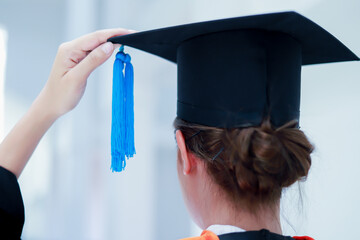 Back view of graduates celebrating their college graduation with pride and joy on graduation day. Congratulations.