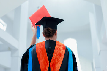 Back view of graduates celebrating their college graduation with pride and joy on graduation day. Congratulations.