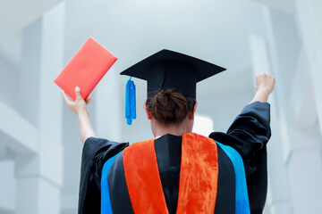 Back view of graduates celebrating their college graduation with pride and joy on graduation day. Congratulations.