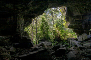 The entrance to Grieg's Caves in Ontario invites exploration amid the stunning natural rock formations and lush greenery.