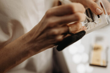 Eyelash extensions. Makeup artist hands take eyelashes