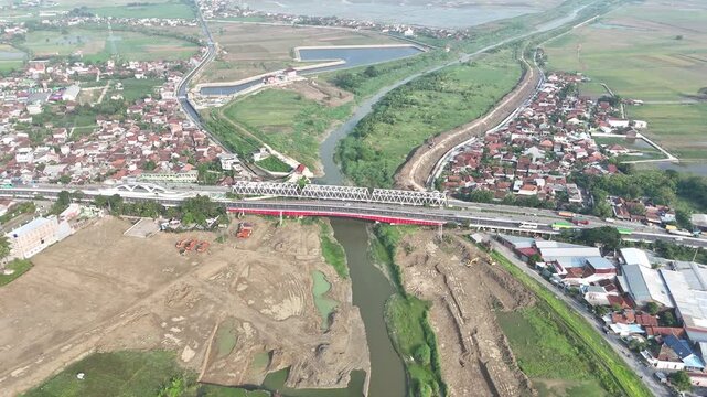 Aerial Perspective Of Java's Landscape Revealing A Railway Crossing The Fields With A River And Lush Village From Above