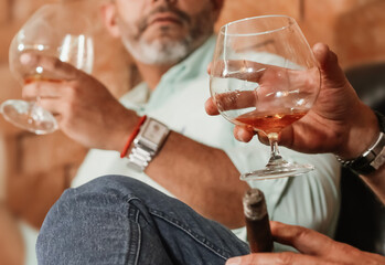 Friends enjoying a glass of brandy and cigars in a luxurious atmosphere