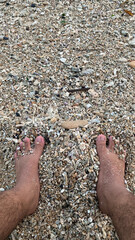 a pair of feet on the rough sand of the beach