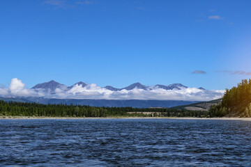 Mountain ridge with clouds covering the middle, peaks and base visible