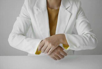 Businesswoman massaging wrist in pain caused by working on a computer keyboard for a long time,...