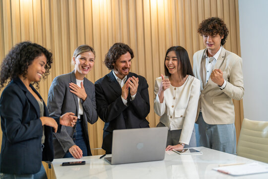 Diverse group business in formal attire smiling and clapping during a corporate meeting, celebrating success and achievements, diverse workplace environment with professional women engaged in teamwork