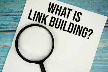What is Link Building? text written on notepad with magnifying glass flat lay on wooden background