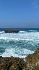 Blue Ocean Waves Crashing on a Rocky Shore