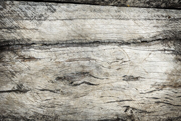 Close-up texture of old weathered wooden surface with natural cracks, rough grain, and rustic patterns, vintage wood background for design, decoration, or material concept.