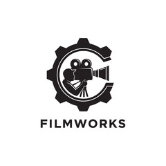 Silhouette of a person filming with a vintage camera inside a gear, with the word 