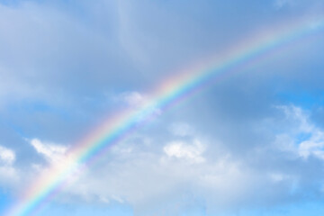 Beautiful colourful rainbow on blue sky after thunderstorm