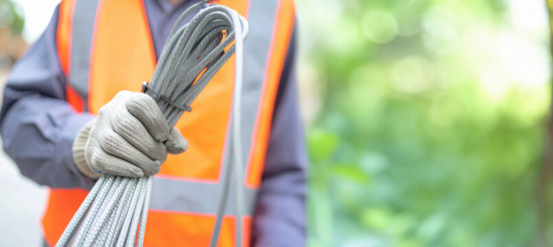 Fototapeta 電気通信工事の手元（ケーブルを持つ）