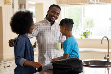 African American family enjoying morning together in kitchen, smiling and talking