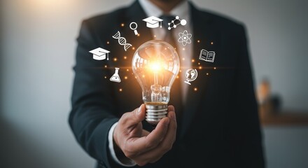 Businessman holding a glowing lightbulb with educational icons