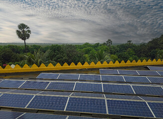 Beautiful view of solar panels with dramatic sky and forest background.