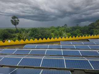 Beautiful view of solar panels with dramatic sky and forest background.