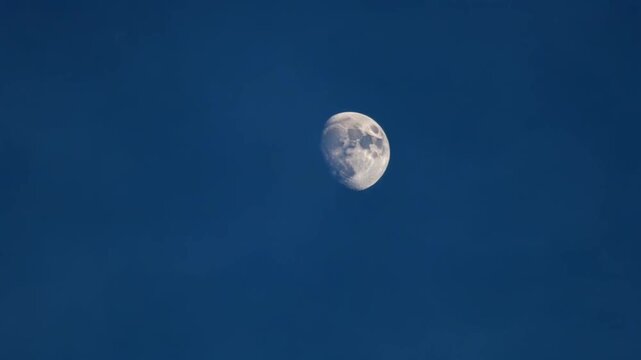 The moon is seen in the blue sky