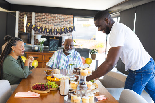 Celebrating retirement, family sharing cupcakes and fruit, enjoying joyful moments together - Powered by Adobe