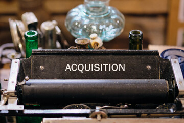 Copy space. Attraction of investments concept. ACQUISITION word written on Antique typewriter machine